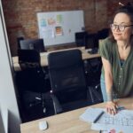 interior-designer-or-architect-in-casual-wear-with-messy-hairdo-smiling-aside-while-working-on-a-1